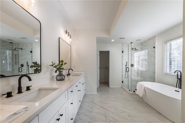 bathroom featuring double vanity, marble finish floor, a stall shower, and a sink