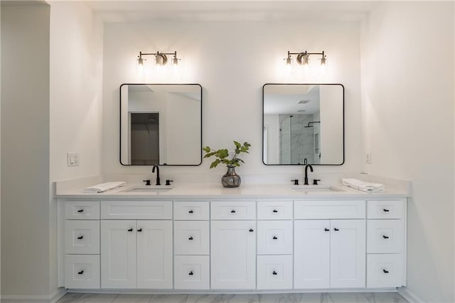 bathroom featuring double vanity, a shower stall, and a sink