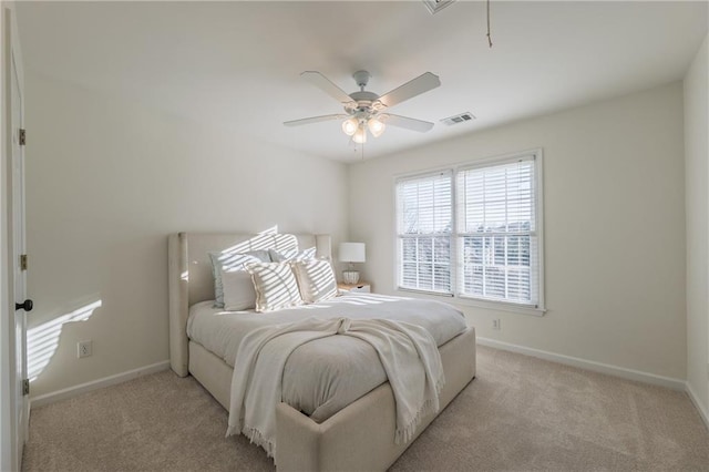 bedroom with visible vents, light carpet, and baseboards