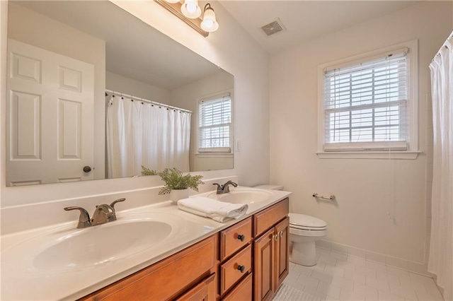 full bath featuring double vanity, visible vents, toilet, and a sink