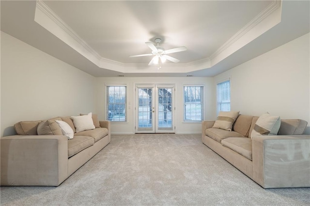 living area with a tray ceiling, carpet floors, crown molding, and french doors