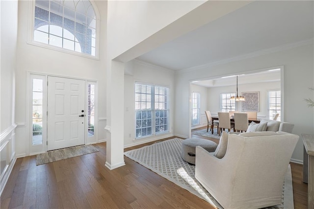 entryway with a healthy amount of sunlight, crown molding, baseboards, and dark wood-style flooring