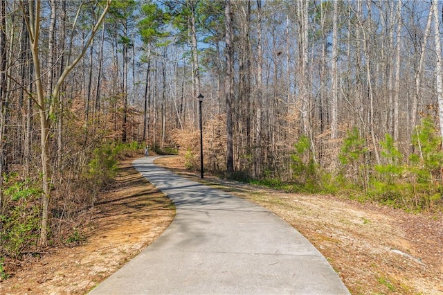 view of road featuring street lighting and a wooded view