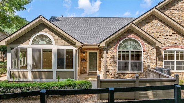5336 Stone Village Cir NW Unit 2, Kennesaw, GA 30152 - back of house featuring stone siding, a fenced front yard, and roof with shingles