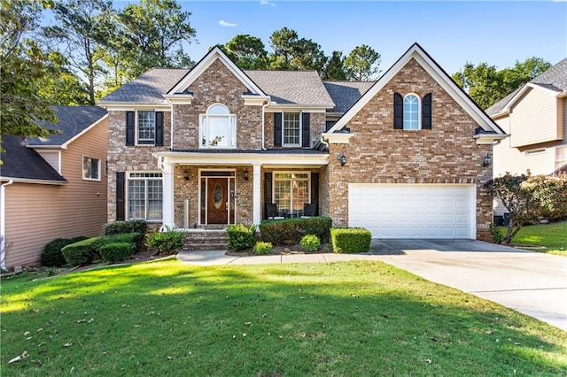 view of front of home with a porch, a front yard, and a garage