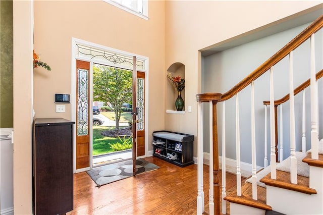 entryway with a towering ceiling and hardwood / wood-style floors