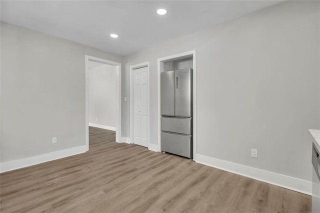 spare room with light wood-style flooring, baseboards, and recessed lighting