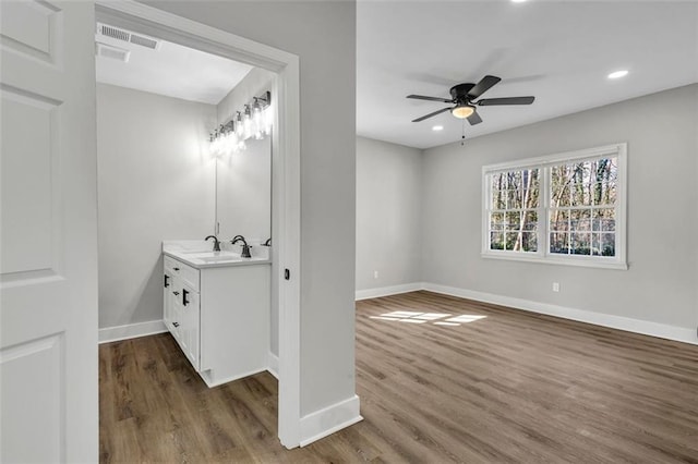 bathroom with ceiling fan, recessed lighting, wood finished floors, vanity, and baseboards