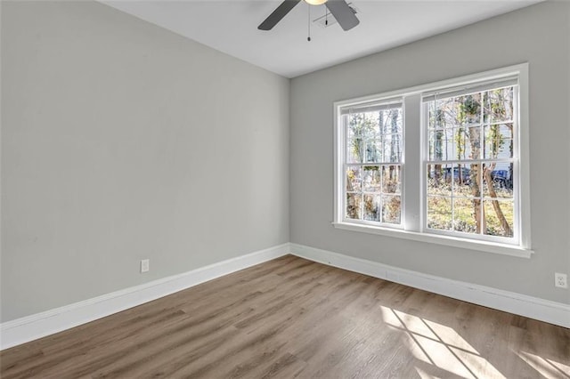 unfurnished room with ceiling fan, baseboards, and wood finished floors