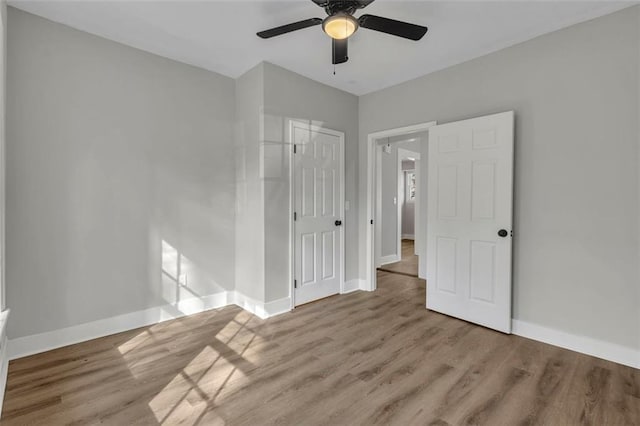 unfurnished bedroom featuring a closet, ceiling fan, baseboards, and wood finished floors