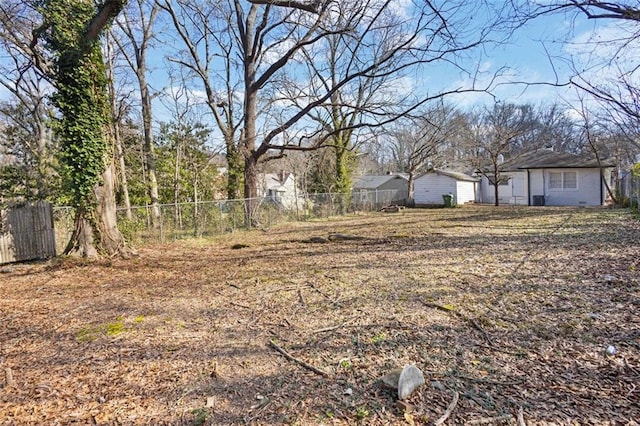 view of yard featuring a garage and fence