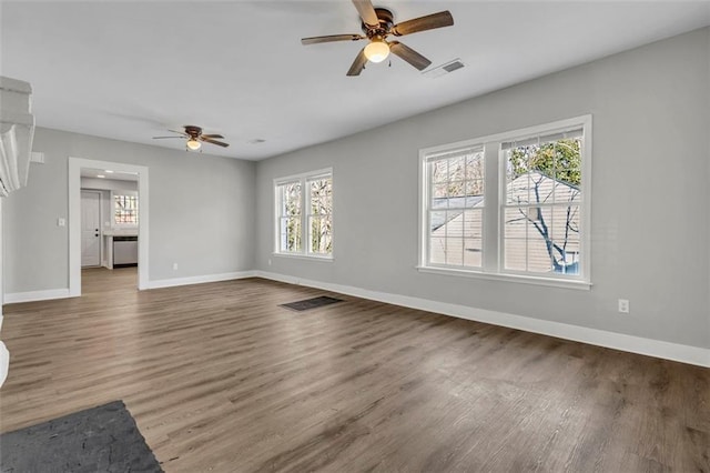 unfurnished living room with visible vents, baseboards, and wood finished floors