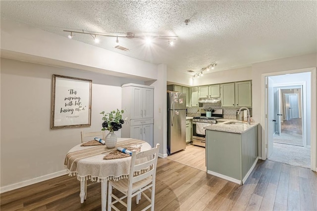 215 Cobblestone Trl, Avondale Estates, GA 30002 - kitchen featuring appliances with stainless steel finishes, green cabinetry, rail lighting, a sink, and a textured ceiling