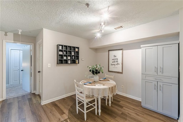 215 Cobblestone Trl, Avondale Estates, GA 30002 - dining room with wood finished floors, a textured ceiling, baseboards, and track lighting