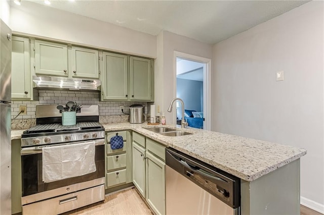 215 Cobblestone Trl, Avondale Estates, GA 30002 - kitchen with appliances with stainless steel finishes, under cabinet range hood, a sink, a peninsula, and light wood-style flooring