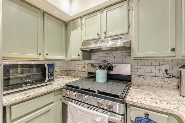 215 Cobblestone Trl, Avondale Estates, GA 30002 - kitchen with under cabinet range hood, appliances with stainless steel finishes, tasteful backsplash, and light stone countertops
