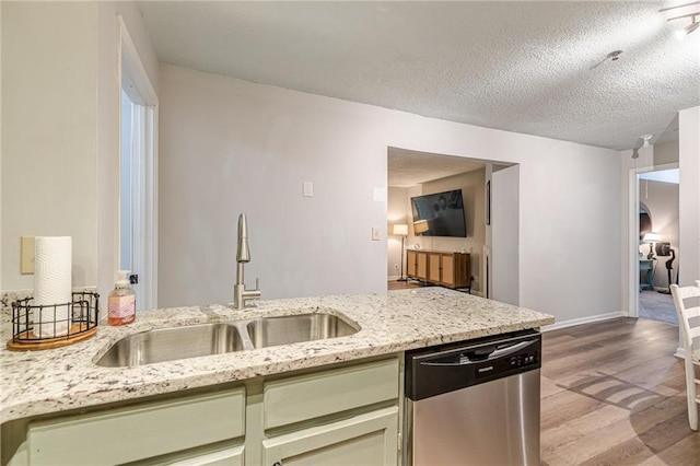 215 Cobblestone Trl, Avondale Estates, GA 30002 - kitchen with a sink, stainless steel dishwasher, light wood-style floors, light stone counters, and a textured ceiling