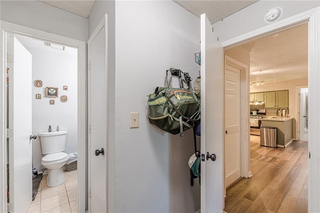 215 Cobblestone Trl, Avondale Estates, GA 30002 - bathroom with a textured ceiling, toilet, wood finished floors, and vanity
