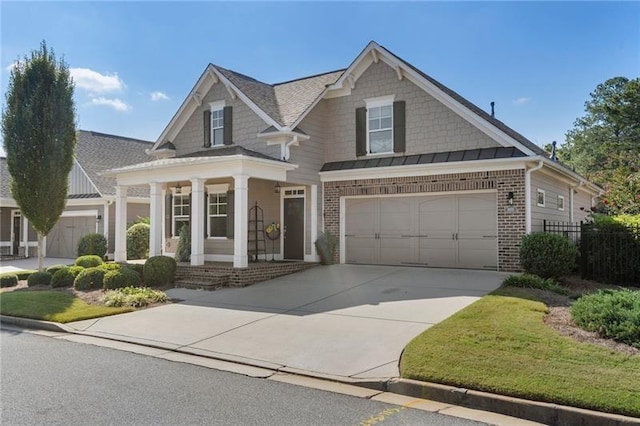 view of front of property featuring brick siding, concrete driveway, a standing seam roof, and metal roof