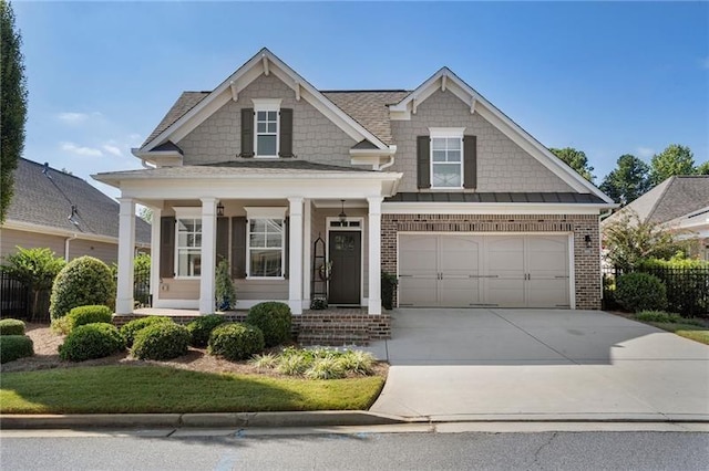 view of front of property with a porch, driveway, an attached garage, and brick siding