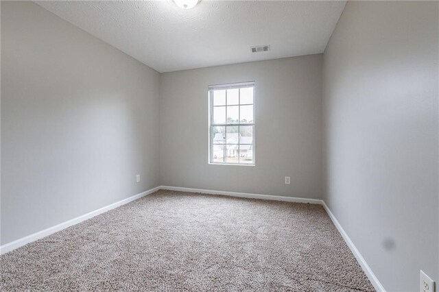 spare room featuring carpet floors and a textured ceiling