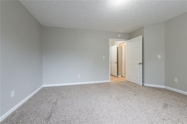 carpeted empty room featuring a textured ceiling