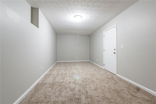 carpeted empty room with a textured ceiling