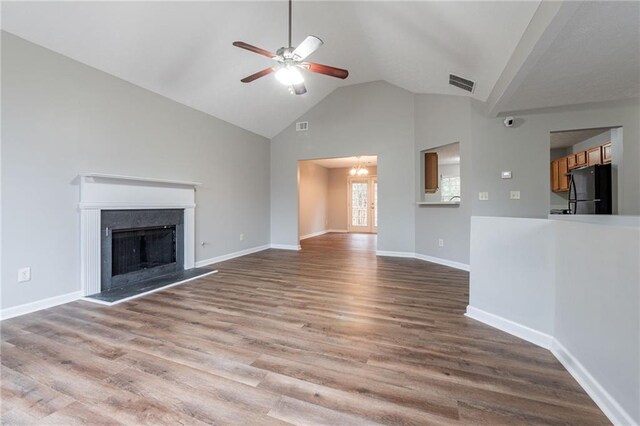 unfurnished living room with hardwood / wood-style flooring, ceiling fan, and high vaulted ceiling