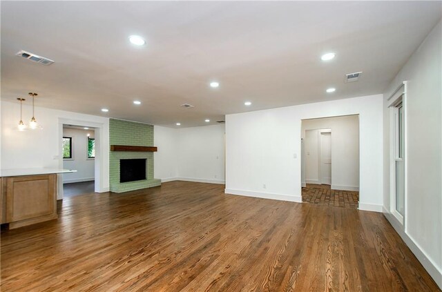 unfurnished living room featuring a fireplace and dark hardwood / wood-style flooring