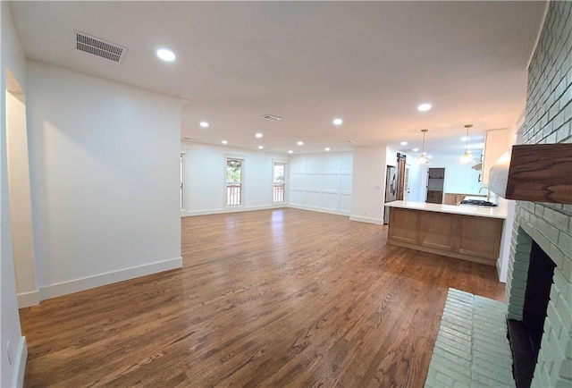 unfurnished living room featuring a fireplace and dark hardwood / wood-style floors