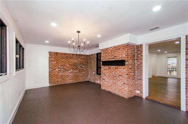 unfurnished living room with brick wall and a notable chandelier