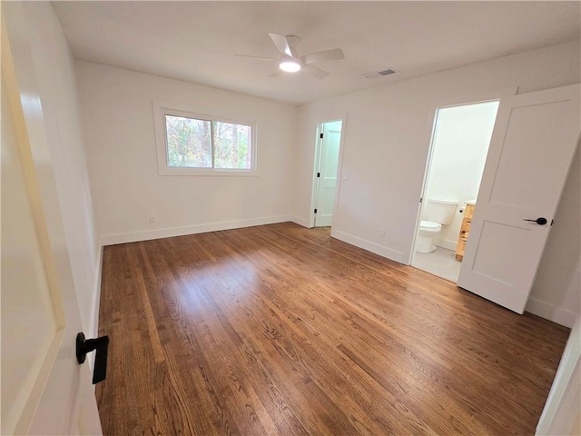 unfurnished bedroom featuring hardwood / wood-style floors, ceiling fan, and ensuite bath