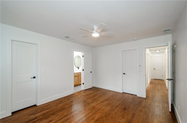 unfurnished bedroom featuring ceiling fan, wood-type flooring, and ensuite bath