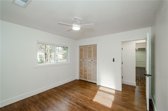 unfurnished bedroom with hardwood / wood-style floors, ceiling fan, and a closet