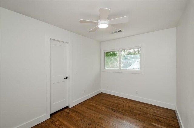 unfurnished room with ceiling fan and dark hardwood / wood-style flooring