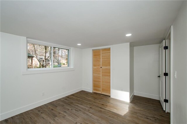 unfurnished bedroom with a closet and dark wood-type flooring