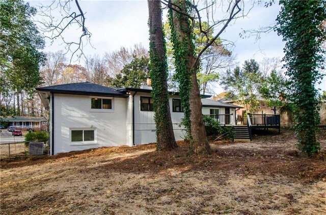 rear view of property with central air condition unit and a wooden deck