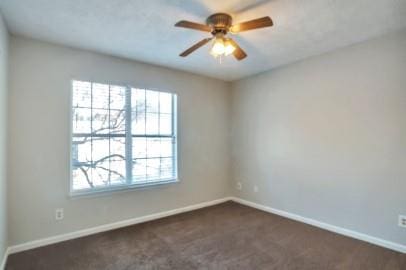 carpeted spare room featuring ceiling fan