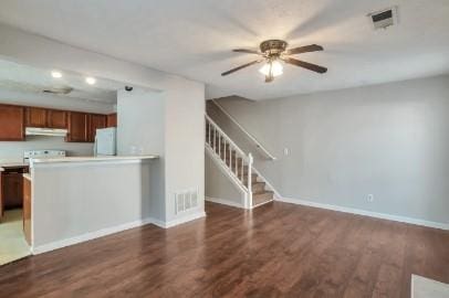 kitchen featuring kitchen peninsula, range, white fridge, and dark hardwood / wood-style floors