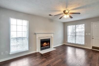 unfurnished living room featuring dark hardwood / wood-style flooring and ceiling fan