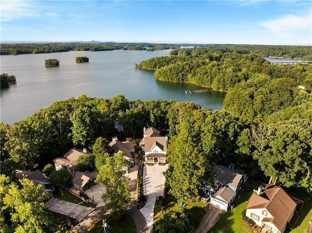 drone / aerial view with a forest view and a water view