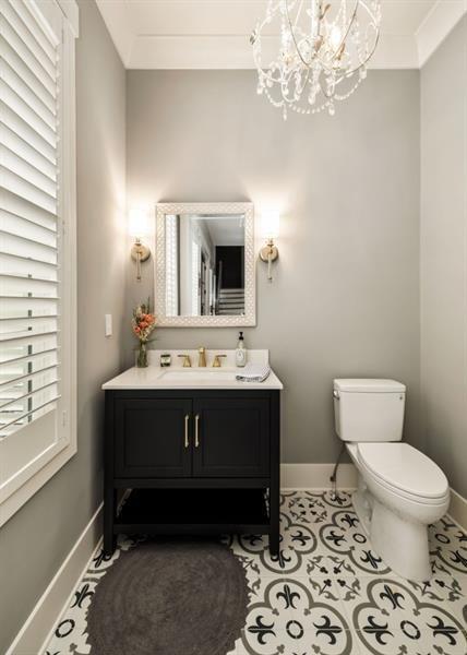 half bath with baseboards, an inviting chandelier, and toilet