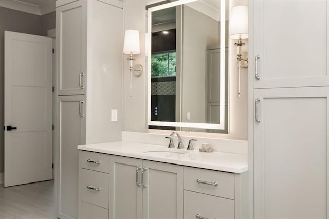 bathroom featuring wood finished floors, vanity, and crown molding