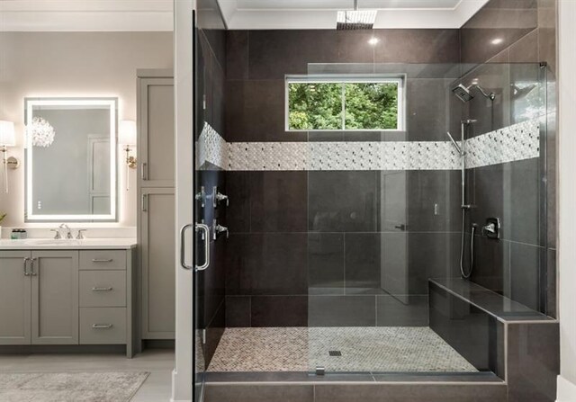 bathroom with vanity, a shower stall, and ornamental molding
