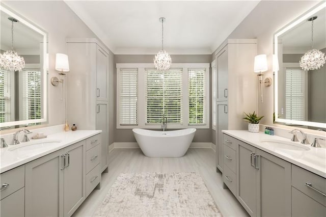full bath featuring baseboards, a sink, and an inviting chandelier