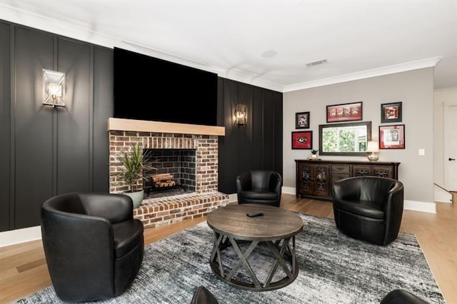 living area with wood finished floors, visible vents, crown molding, baseboards, and a brick fireplace