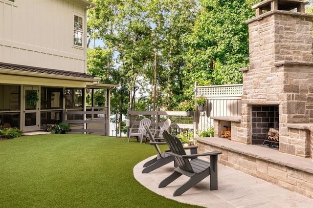 view of yard featuring a patio area and an outdoor stone fireplace