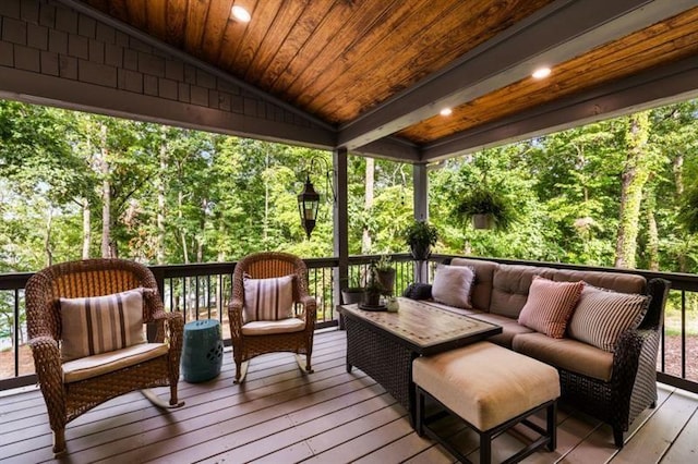 wooden deck with outdoor lounge area and a view of trees