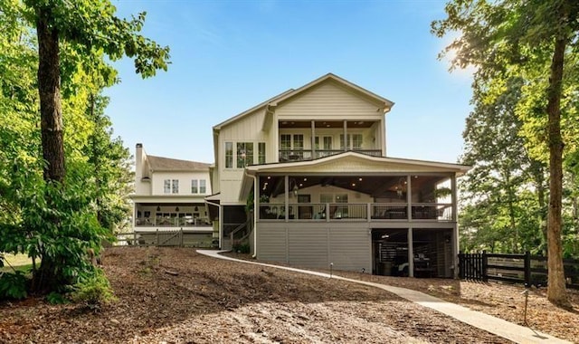 rear view of house featuring a sunroom and fence