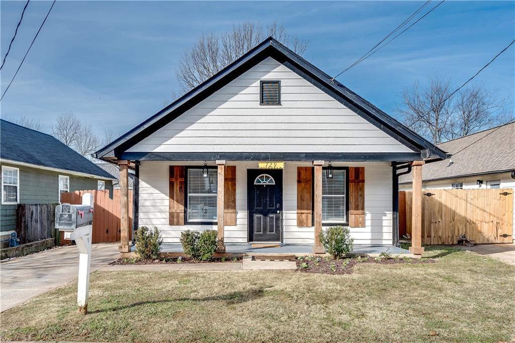 bungalow-style home with covered porch and a front lawn